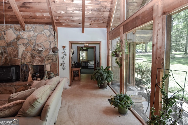 carpeted living room with wood ceiling and a stone fireplace