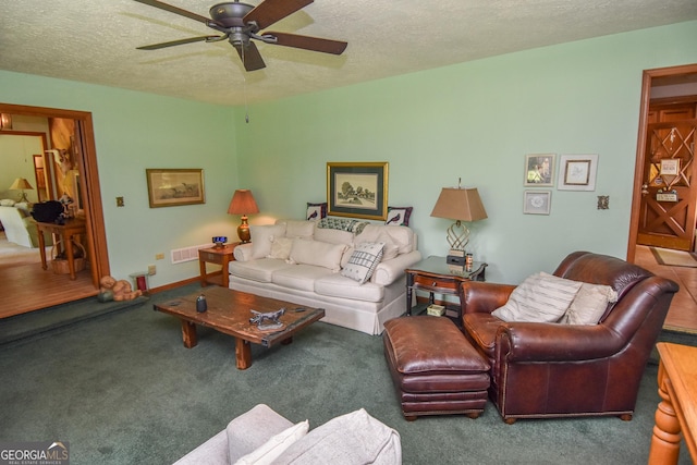 living room with a ceiling fan, a textured ceiling, and carpet floors
