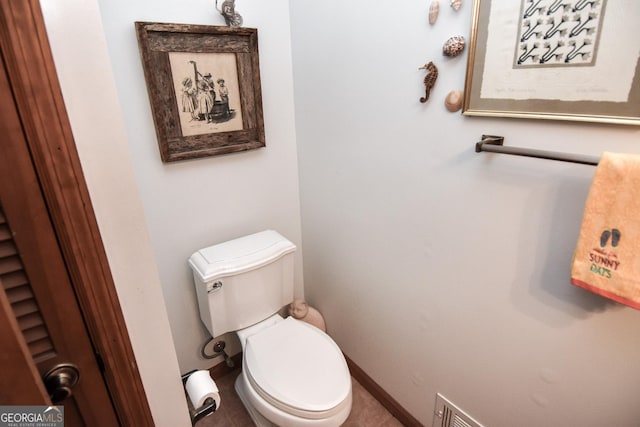 bathroom with toilet and baseboards