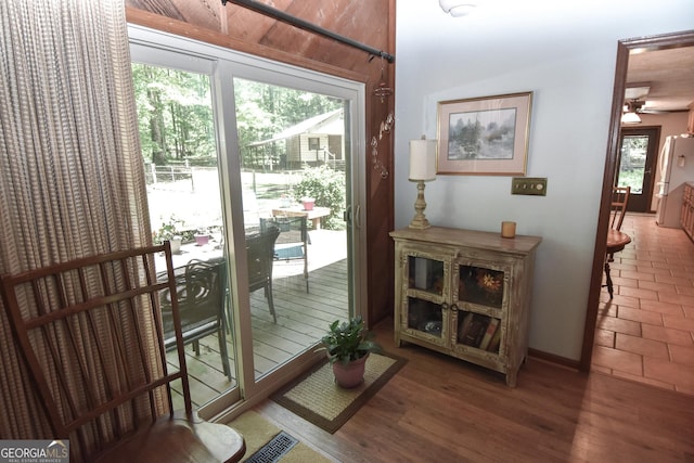 doorway to outside featuring a ceiling fan and baseboards