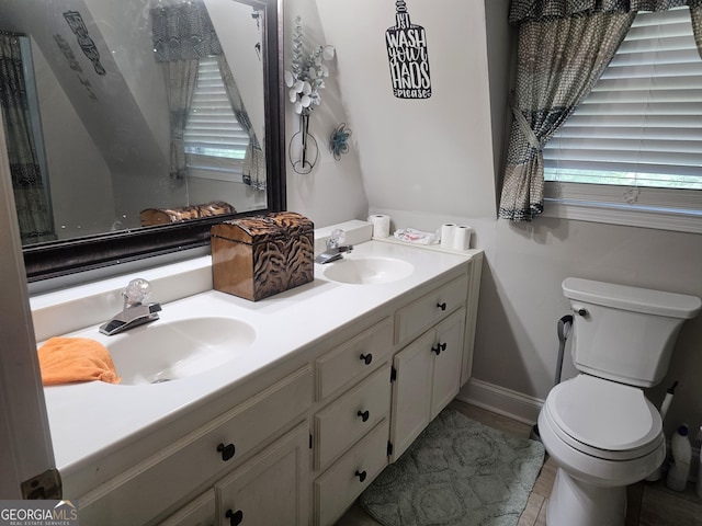 605 Smithville Church Rd, Warner Robins, GA 31088 - bathroom featuring toilet, double vanity, and baseboards