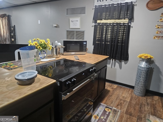 605 Smithville Church Rd, Warner Robins, GA 31088 - kitchen with black electric range oven, dark wood-type flooring, baseboards, and dark cabinets