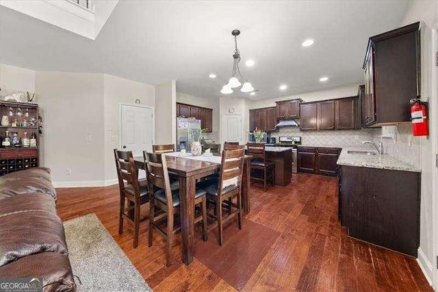 dining space featuring dark wood-style floors, baseboards, recessed lighting, and a chandelier
