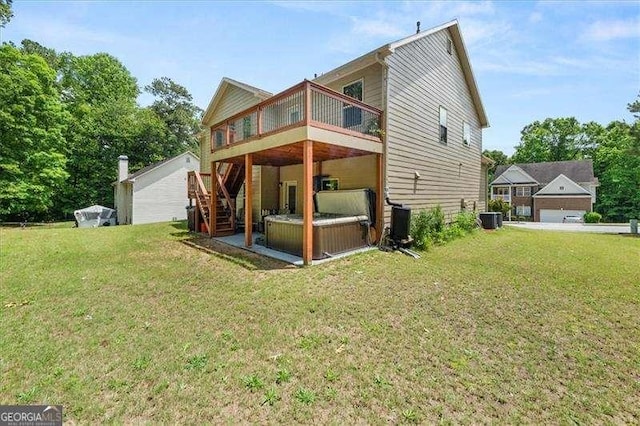back of property with a deck, stairway, central AC unit, and a yard