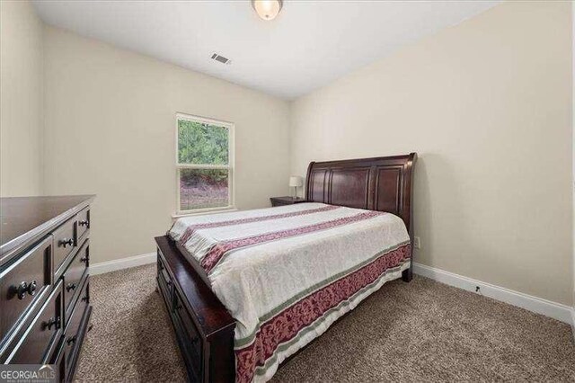 bedroom with dark carpet and baseboards