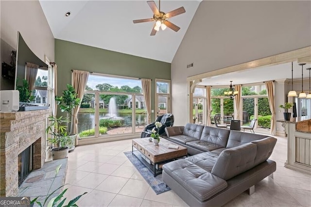 living room featuring high vaulted ceiling, light tile patterned floors, a chandelier, a ceiling fan, and a fireplace