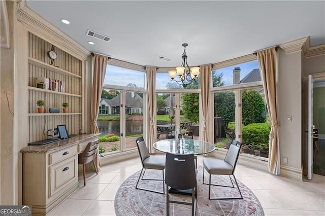 dining space featuring light tile patterned flooring, a chandelier, a water view, and expansive windows
