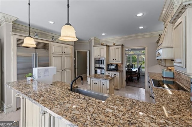 kitchen featuring black appliances, a sink, cream cabinets, a center island, and crown molding