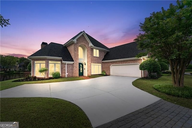 9325 Saint Georgen Cmn, Duluth, GA 30097 - view of front of house with driveway, brick siding, a garage, a yard, and a chimney