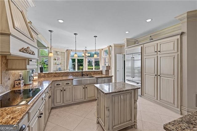 kitchen with appliances with stainless steel finishes, cream cabinets, tasteful backsplash, a sink, and light tile patterned floors