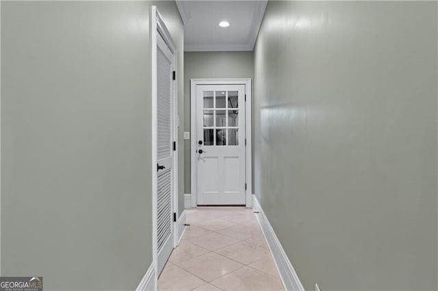 entryway with light tile patterned floors, baseboards, and crown molding