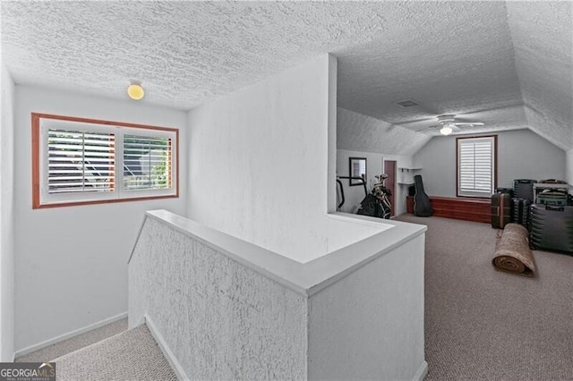 additional living space featuring carpet, a textured ceiling, a ceiling fan, lofted ceiling, and baseboards