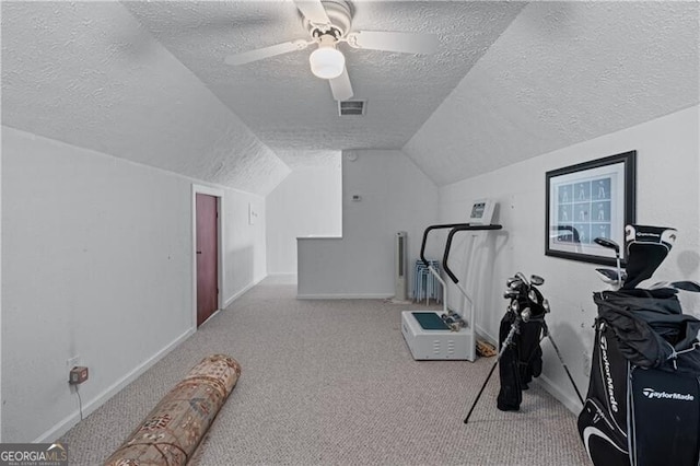 exercise area with a textured ceiling, carpet flooring, baseboards, vaulted ceiling, and ceiling fan