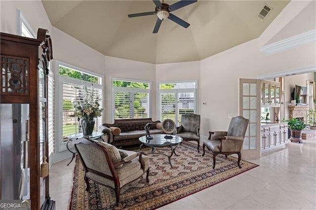 living room with a ceiling fan, healthy amount of natural light, high vaulted ceiling, and light tile patterned floors