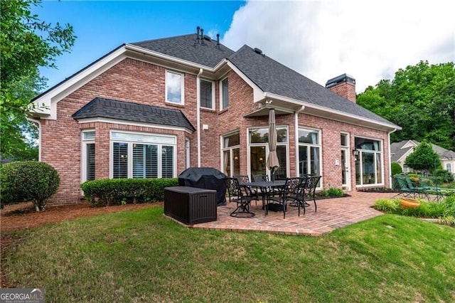 9325 Saint Georgen Cmn, Duluth, GA 30097 - back of property featuring brick siding, a patio area, a yard, a chimney, and a shingled roof