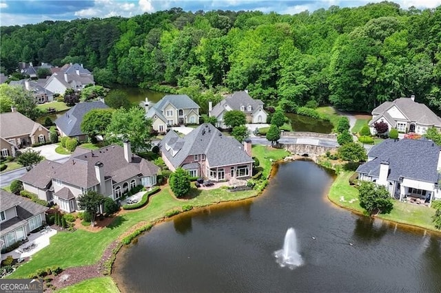 aerial overview of property's location with nearby suburban area, a large body of water, and a heavily wooded area