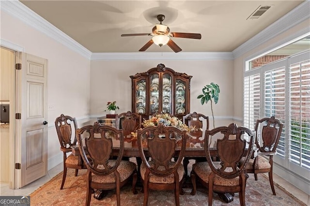 dining area featuring ceiling fan, ornamental molding, and light tile patterned floors