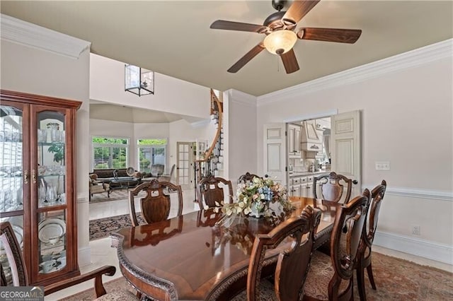 dining area with a ceiling fan, ornamental molding, and baseboards