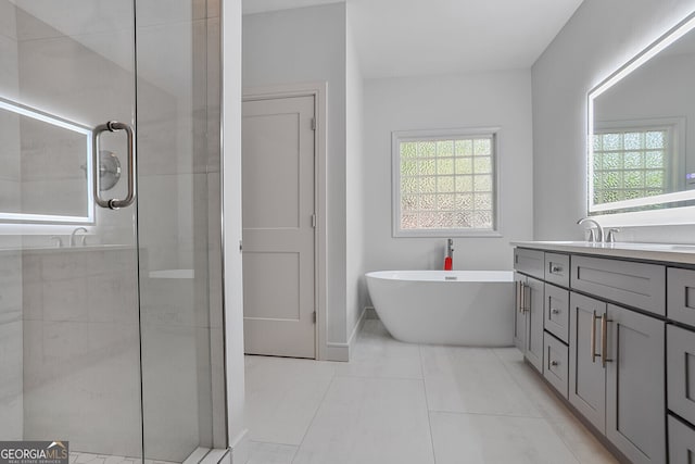 bathroom featuring a tile shower, vanity, a freestanding tub, and healthy amount of natural light