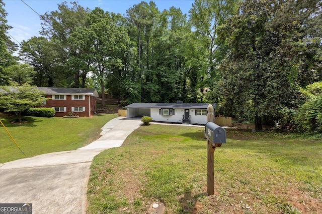 view of front of property with concrete driveway, a front lawn, and a carport