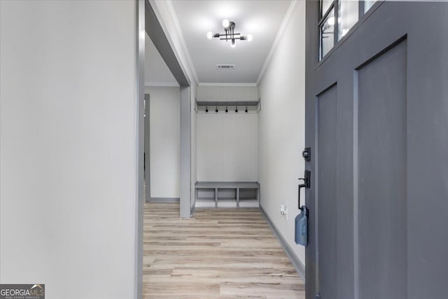 entryway with ornamental molding, light wood-type flooring, and baseboards