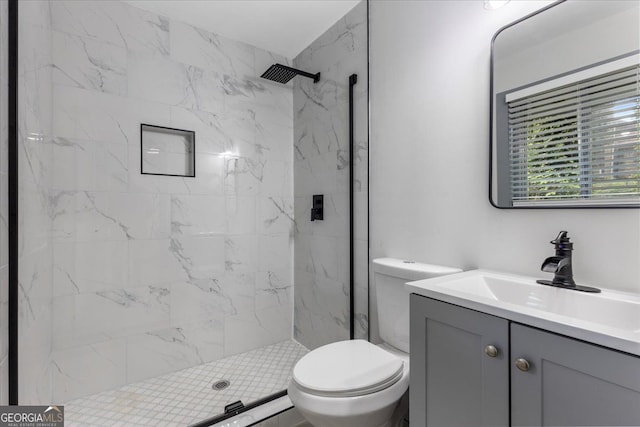 full bath featuring a marble finish shower, toilet, and vanity