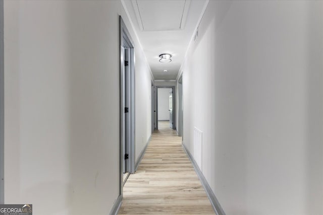 hallway with light wood-style floors and baseboards