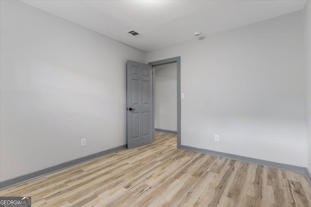 unfurnished room with light wood-style flooring and baseboards