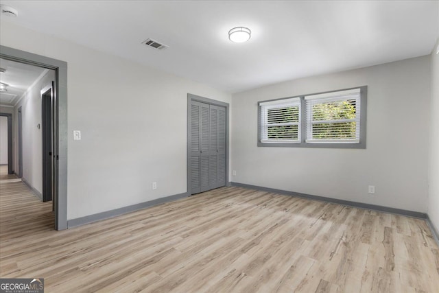 unfurnished room with light wood-style flooring and baseboards
