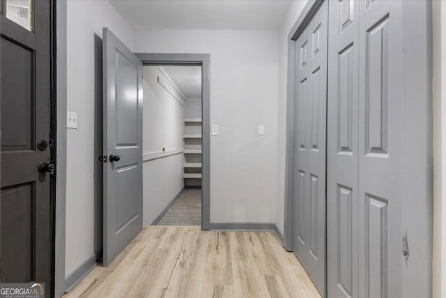 hallway with light wood-style flooring and baseboards