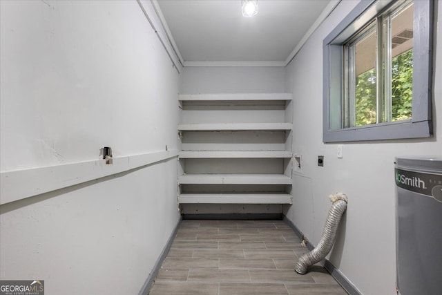 washroom featuring electric dryer hookup, ornamental molding, baseboards, and wood finished floors