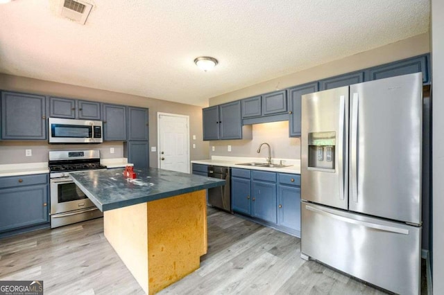 3730 Warriors Path, Decatur, GA 30034 - kitchen featuring stainless steel appliances, a sink, light wood-style flooring, a center island, and a textured ceiling