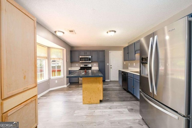 3730 Warriors Path, Decatur, GA 30034 - kitchen with stainless steel appliances, wood finished floors, a textured ceiling, a center island, and baseboards