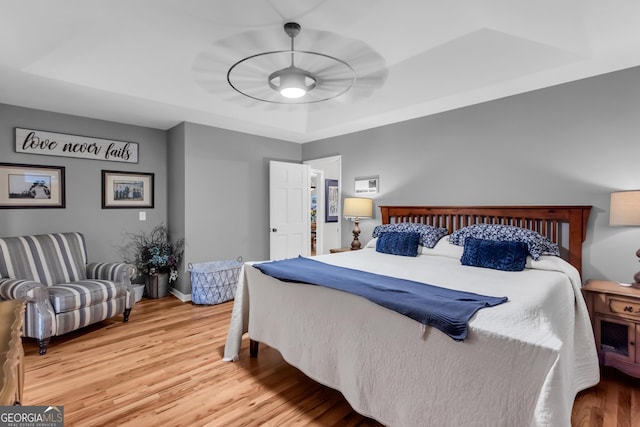 739 Rockford Creek Rd, Clarkesville, GA 30523 - bedroom with light wood-style flooring, a tray ceiling, and baseboards