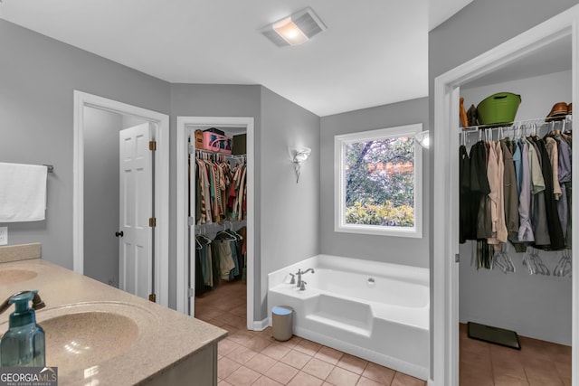 739 Rockford Creek Rd, Clarkesville, GA 30523 - bathroom with tile patterned flooring, a bath, a spacious closet, double vanity, and baseboards