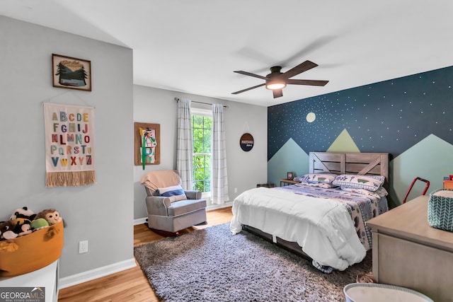 739 Rockford Creek Rd, Clarkesville, GA 30523 - bedroom with wood finished floors, an accent wall, baseboards, wallpapered walls, and ceiling fan