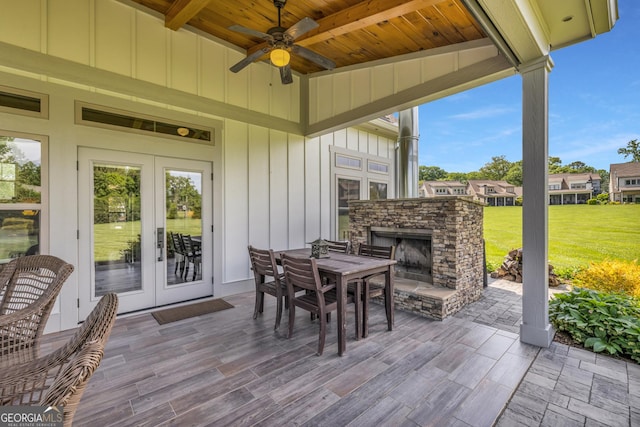 view of patio with an outdoor stone fireplace and ceiling fan