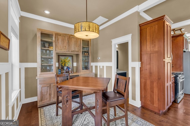 dining area featuring dark wood-type flooring and wainscoting