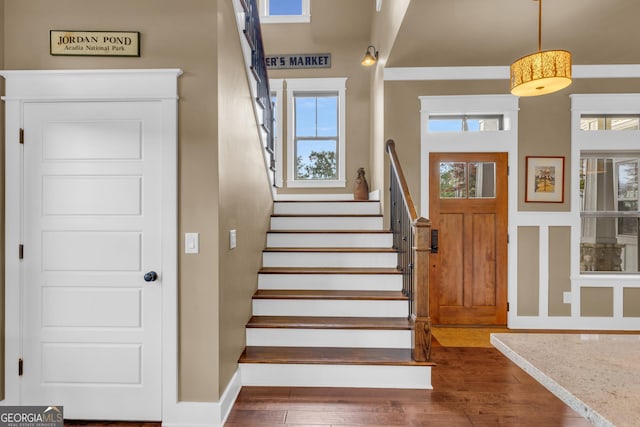 stairway featuring hardwood / wood-style floors and a towering ceiling