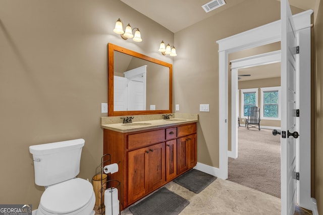 full bathroom featuring double vanity, toilet, and baseboards