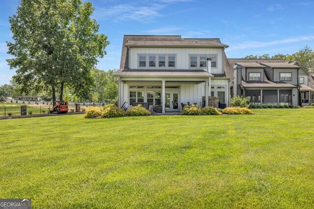 rear view of property with french doors, board and batten siding, and a sunroom
