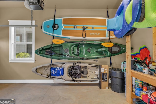 detailed view of a garage door opener, concrete floors, and baseboards