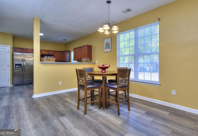 2326 Nicole Dr, Hampton, GA 30228 - dining room with dark wood-type flooring, healthy amount of natural light, a chandelier, and a textured ceiling