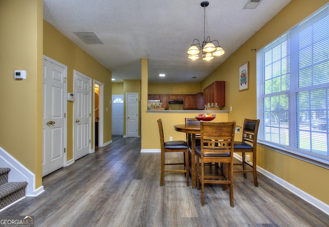 2326 Nicole Dr, Hampton, GA 30228 - dining area with dark wood-style floors, a chandelier, plenty of natural light, a textured ceiling, and baseboards