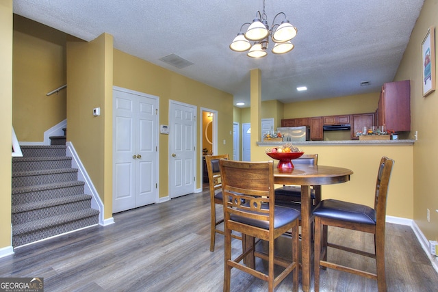 2326 Nicole Dr, Hampton, GA 30228 - dining space with wood finished floors, a textured ceiling, a chandelier, stairway, and baseboards