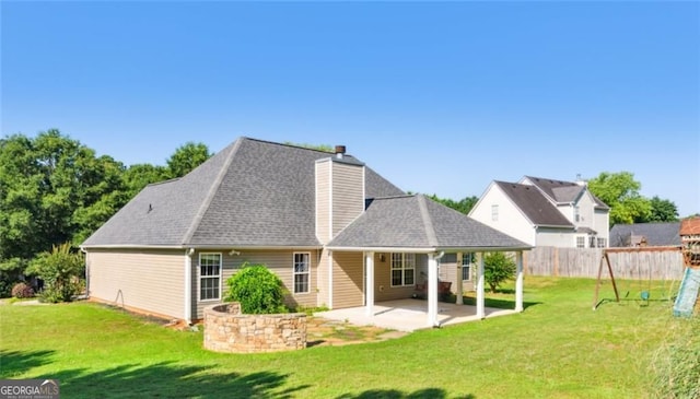 rear view of house with a patio area, a chimney, and roof with shingles