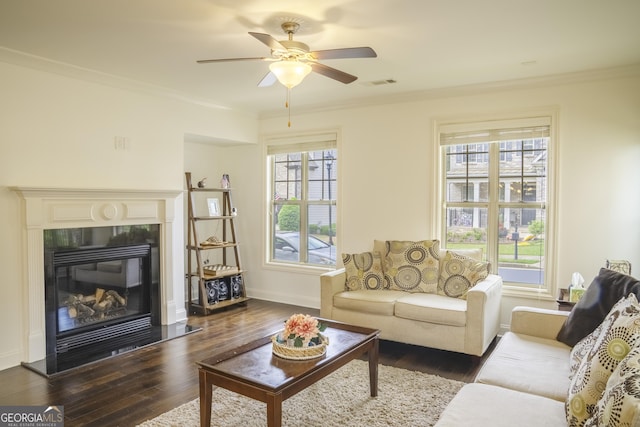 4448 Tacoma Trce, Suwanee, GA 30024 - living room with dark wood-style flooring, crown molding, baseboards, a ceiling fan, and a glass covered fireplace