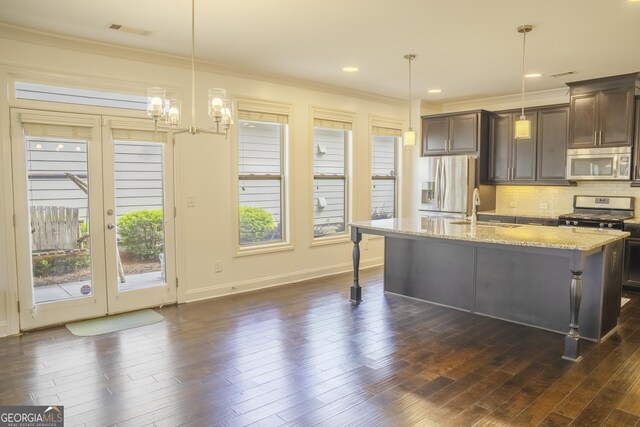 4448 Tacoma Trce, Suwanee, GA 30024 - kitchen with appliances with stainless steel finishes, a sink, dark brown cabinetry, a center island with sink, and light stone countertops