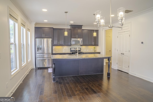 4448 Tacoma Trce, Suwanee, GA 30024 - kitchen featuring stainless steel appliances, tasteful backsplash, dark brown cabinets, light stone countertops, and an island with sink