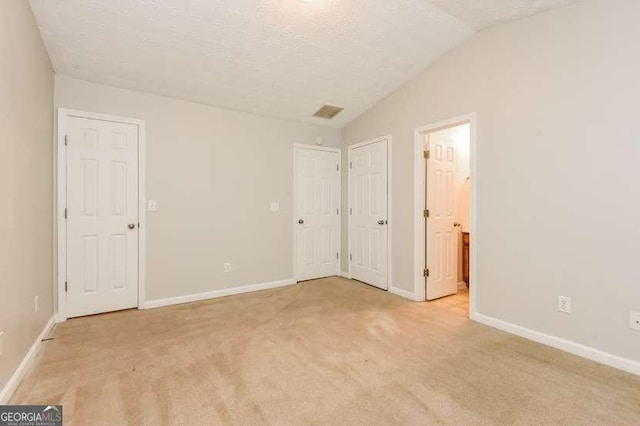 2838 Vining Ridge Ter Unit 0, Decatur, GA 30034 - unfurnished bedroom featuring a textured ceiling, light colored carpet, baseboards, lofted ceiling, and connected bathroom